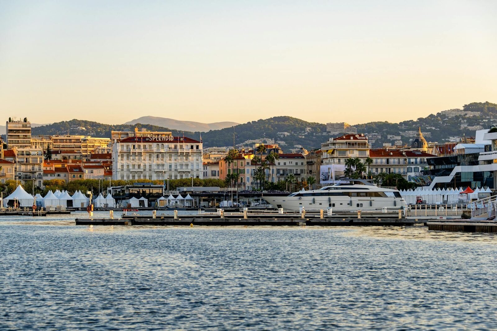 Cannes Vieux Port at sunset with a superyacht moored during the Cannes Yachting Festival