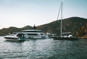 Luxury yachts anchored in a calm Mediterranean bay while choosing a yacht charter company