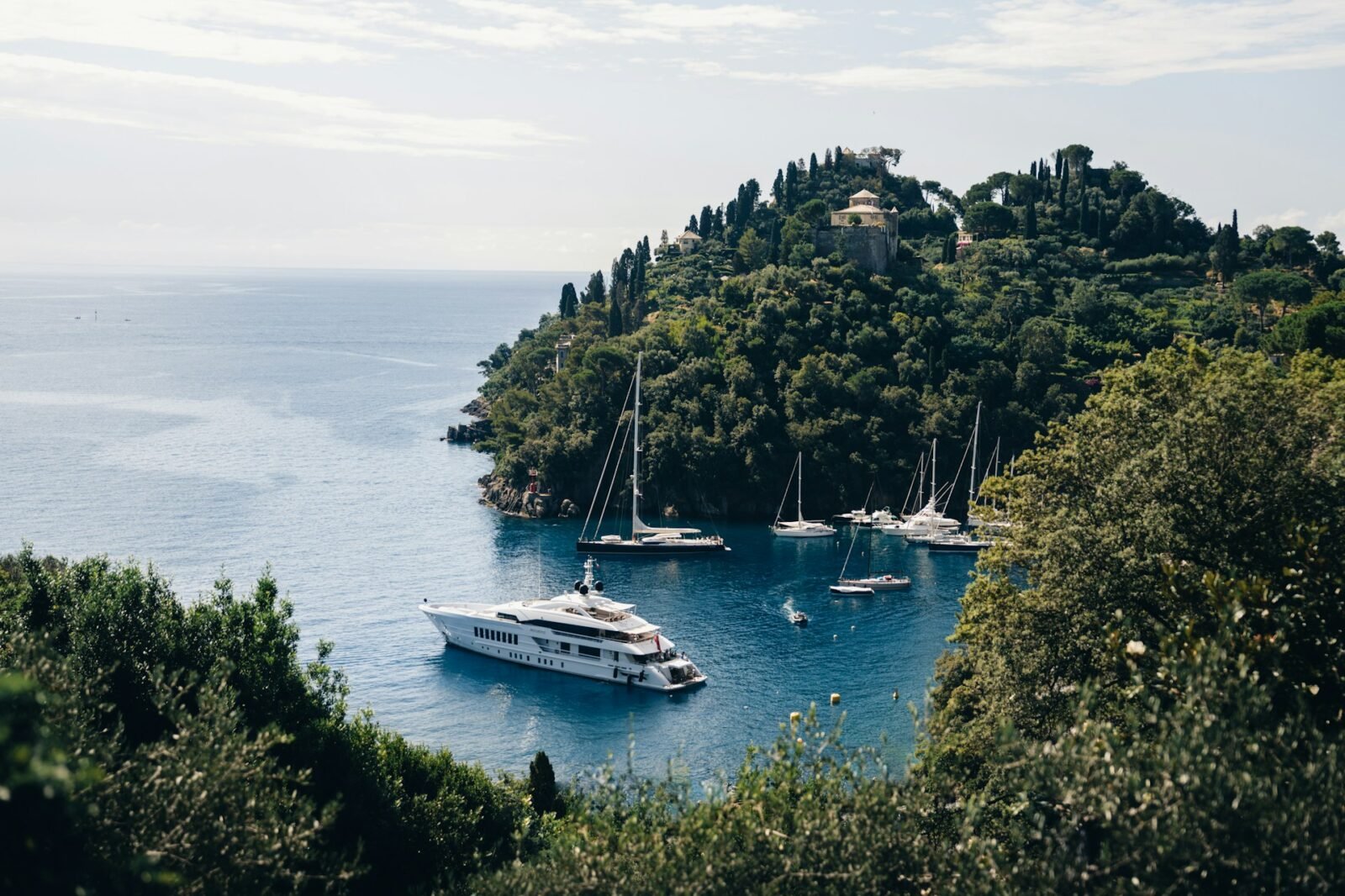 Superyachts anchored in Portofino’s calm bay — a real-world snapshot of how itinerary and location shape Mediterranean yacht charter cost.