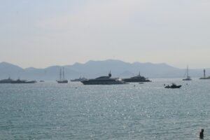 Yachts at anchor off Cannes with hazy mountains on the horizon