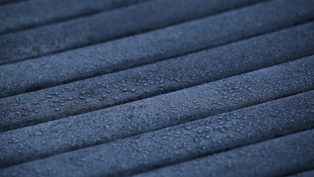 Water droplets on a textured marine-grade material surface used in luxury yacht interiors. marine-grade-materials-yacht-interiors