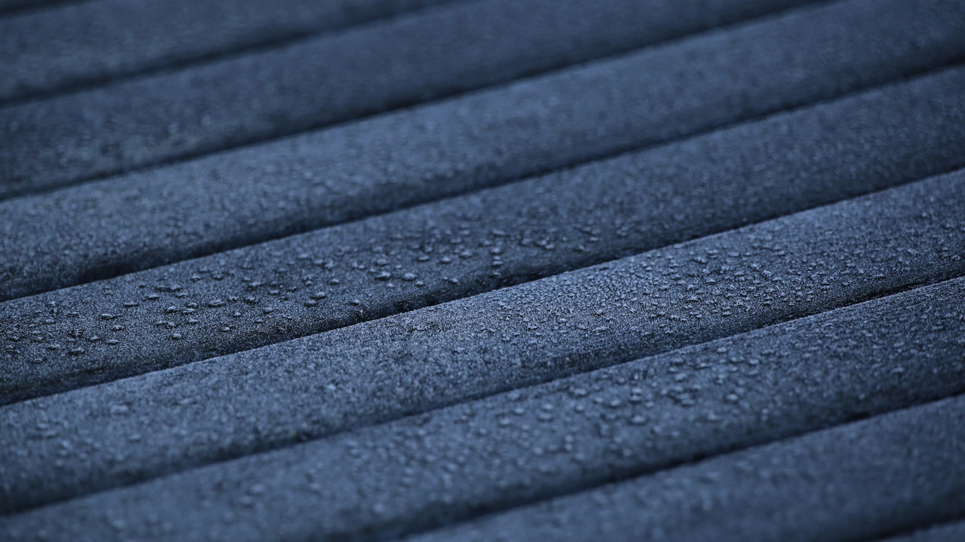 Water droplets on a textured marine-grade material surface used in luxury yacht interiors.